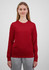 A long sleeve women's tee in bright red, displayed by a model in grey trousers, featuring a logo.