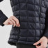 A women's puffer jacket in navy blue, featuring a quilted design and side zipper pockets. Includes branding.