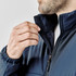 A close-up of a man wearing a navy blue Sierra Thermal Jacket, showcasing the collar and zipper detail.