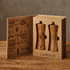 A wooden salt and pepper set in a gift box, featuring a rustic design and a branded logo.