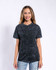 A woman models a black mineral wash adult T-shirt, featuring a casual fit and a subtle distressed look.