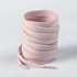 A coil of light pink shoe laces with plastic tips, featuring a textured finish and a logo.