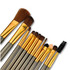A 12-piece brush set featuring various brushes with gold and silver handles in a metal box.