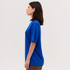 A blue short-sleeve tee is displayed on a model from a side view, featuring a simple design and a comfortable fit.