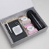 A gift box containing a black drink bottle, a notebook, a pen, a speaker, and assorted snacks.