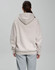 An oversized unisex hoodie in a light beige colour, featuring a spacious hood, shown from the back.