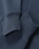 A close-up of blue fleece fabric featuring ribbed cuffs of an oversized unisex hoodie with a logo.