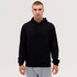 A man wearing a black hoodie with a front pocket, paired with grey sweatpants. The hoodie has a drawstring hood.