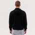 A black zip hoodie with a hood, viewed from the back, paired with light grey pants. It features a logo.
