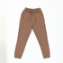 Brown track pants with an elastic waistband and tapered legs, featuring a branding logo.