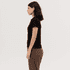 A black women's polo shirt is displayed on a model, shown in profile. The design includes short sleeves and a fitted shape.