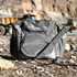 A grey cooler bag with a shoulder strap and multiple compartments, featuring a logo on the front.