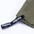 A green cooling towel with a black strap featuring a logo. The towel has a textured surface and is neatly folded.