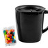 A black mug with a lid alongside a pack of colourful jelly beans. The mug has a simple design and a handle.