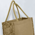 A jute tote bag in a natural beige colour with twin handles and a patterned side design. It's unbranded.
