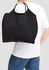 A black nylon tote bag is being carried over the shoulder by a person wearing a white shirt and blue jeans.