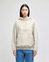 A light grey pullover hooded sweatshirt with a front pocket and a logo on the sleeve, worn by a model.