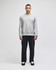 A grey crew sweatshirt worn by a model, paired with black trousers, featuring a subtle logo.