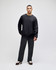A black crew sweatshirt displayed on a model paired with dark pants and sneakers, featuring a logo.