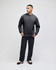 A man wearing a dark grey Champion Powerblend® adult crewneck sweatshirt paired with black pants.