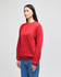 A red crewneck sweatshirt with long sleeves, featuring a logo on the sleeve, displayed on a model.