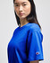 A blue Champion adult short-sleeve t-shirt displayed on a model, featuring a logo on the sleeve.