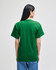 A green short-sleeve t-shirt is displayed on a model seen from the back. The shirt features a logo.