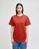 A red short-sleeve t-shirt with a logo, displayed on a model in casual denim jeans.