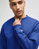 A blue Champion adult short-sleeve t-shirt with a logo, displayed on a model.