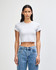 A grey women's crop fitted T-shirt with short sleeves, paired with high-waisted denim jeans, featuring a logo.