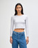 A fitted grey long-sleeve crop t-shirt displayed on a model, paired with blue jeans. The shirt features a logo.