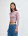 A fitted long-sleeve crop T-shirt in a soft lavender colour, worn by a model with straight hair, paired with blue jeans.