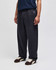 Open-bottom fleece pants in dark grey featuring pockets and a logo, worn by a person standing.