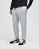 A man wearing grey fleece joggers with an unspecified logo, paired with a long-sleeve black top and shoes.