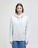 A light grey full-zip hooded sweatshirt with a front pocket and a logo on the sleeve, worn by a model.