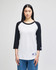 A white and black Champion Adult Raglan Baseball T-Shirt displayed on a model, featuring a logo on the sleeve.