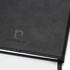 A black diary with a textured cover and a logo embossed on the front. It has a ribbon bookmark.