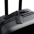 A black suitcase featuring a sleek leather luggage tag with a braided attachment. It has a minimalist design and a logo.