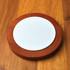 A wireless charger featuring a sleek design with a wooden base and a smooth white charging surface.