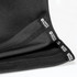 A black unisex T-shirt with a textured fabric, featuring a logo tag on the hem.