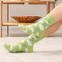 Bright green knitted socks featuring a cloud and rain pattern, set against a light background.