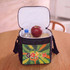 A lunch cooler bag in black with a colourful interior, containing a drink bottle, apple, and lunch box.