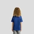 A blue children's T-shirt featuring a plain back design. The model has curly hair and is wearing grey pants.
