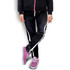 Black sports pants with white and yellow stripes, paired with pink sneakers, showcased on a model.