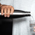 A drink bottle in stainless steel pours water into a glass, featuring a sleek design and insulated construction.