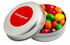 A silver tin filled with colourful Skittles in red, green, yellow, orange, and purple. The tin has a circular logo.