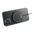 A round black wireless charging pad placed on the back of a smartphone. The pad has a logo.
