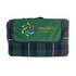 A folded picnic rug featuring a green and tartan check pattern, with a logo on the front.