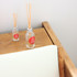 A 10ml clear glass reed diffuser with wooden sticks, positioned on a wooden surface next to a smaller similar diffuser.