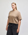A mid-length, boxy top in a light brown hue, featuring a relaxed fit and short sleeves, with a logo present.